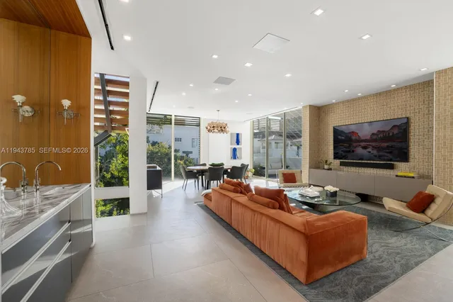 a living room with furniture kitchen view and a large window