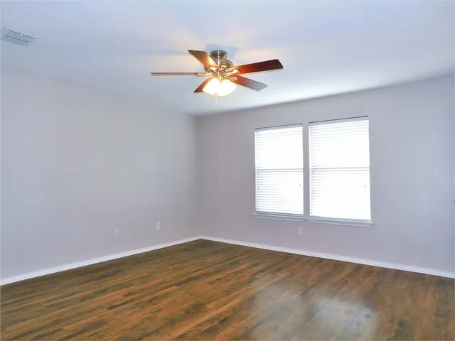 an empty room with a window and a fan