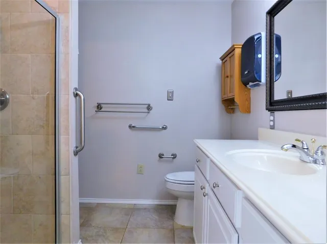 a bathroom with a sink a toilet and shower