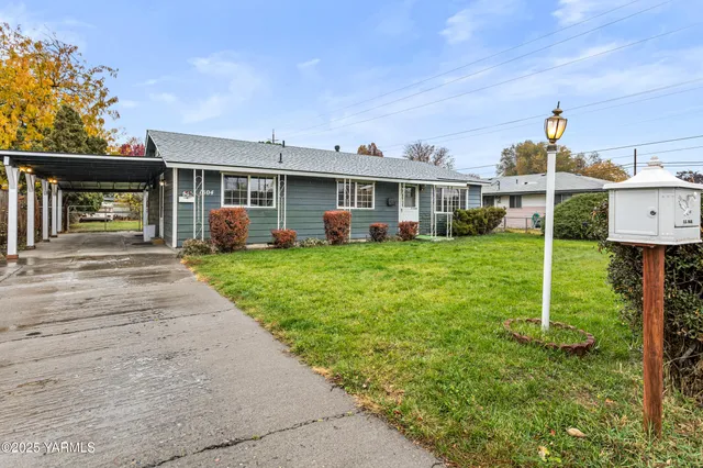 a front view of a house with a yard and trees
