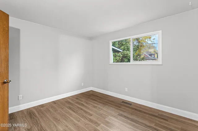 wooden floor in an empty room with a window