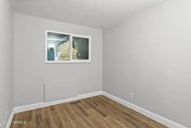 a view of an empty room with wooden floor