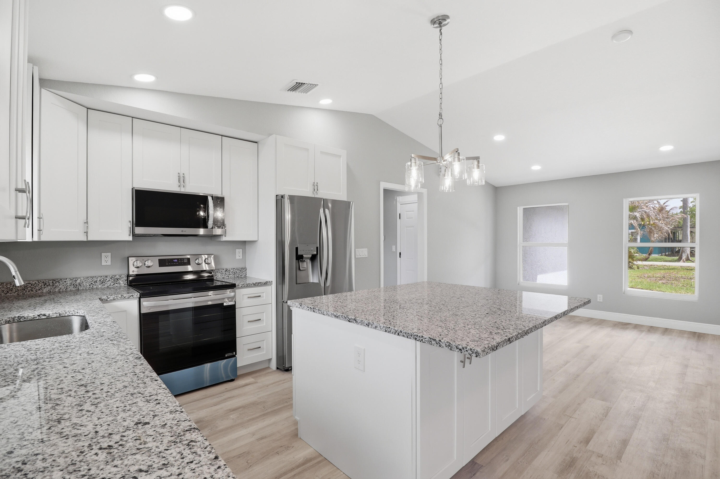 2805 Southeast Carroll Street Stuart, FL 34997 - Photo 3 of 21 a kitchen with stainless steel appliances granite countertop a sink a stove a refrigerator and a oven