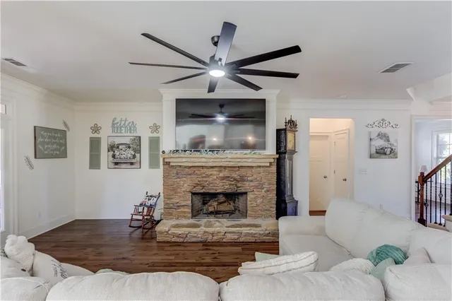 a living room with furniture kitchen view and a wooden floor