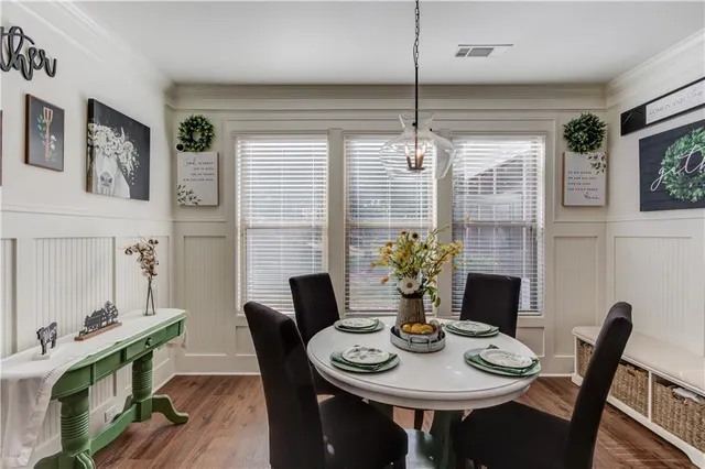 a open kitchen with stainless steel appliances granite countertop a stove sink refrigerator dining table and chairs with wooden floor