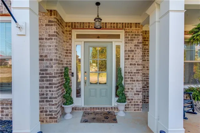 a view of a porch with chairs and potted plants