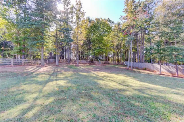 a view of a house with a small yard and a large tree