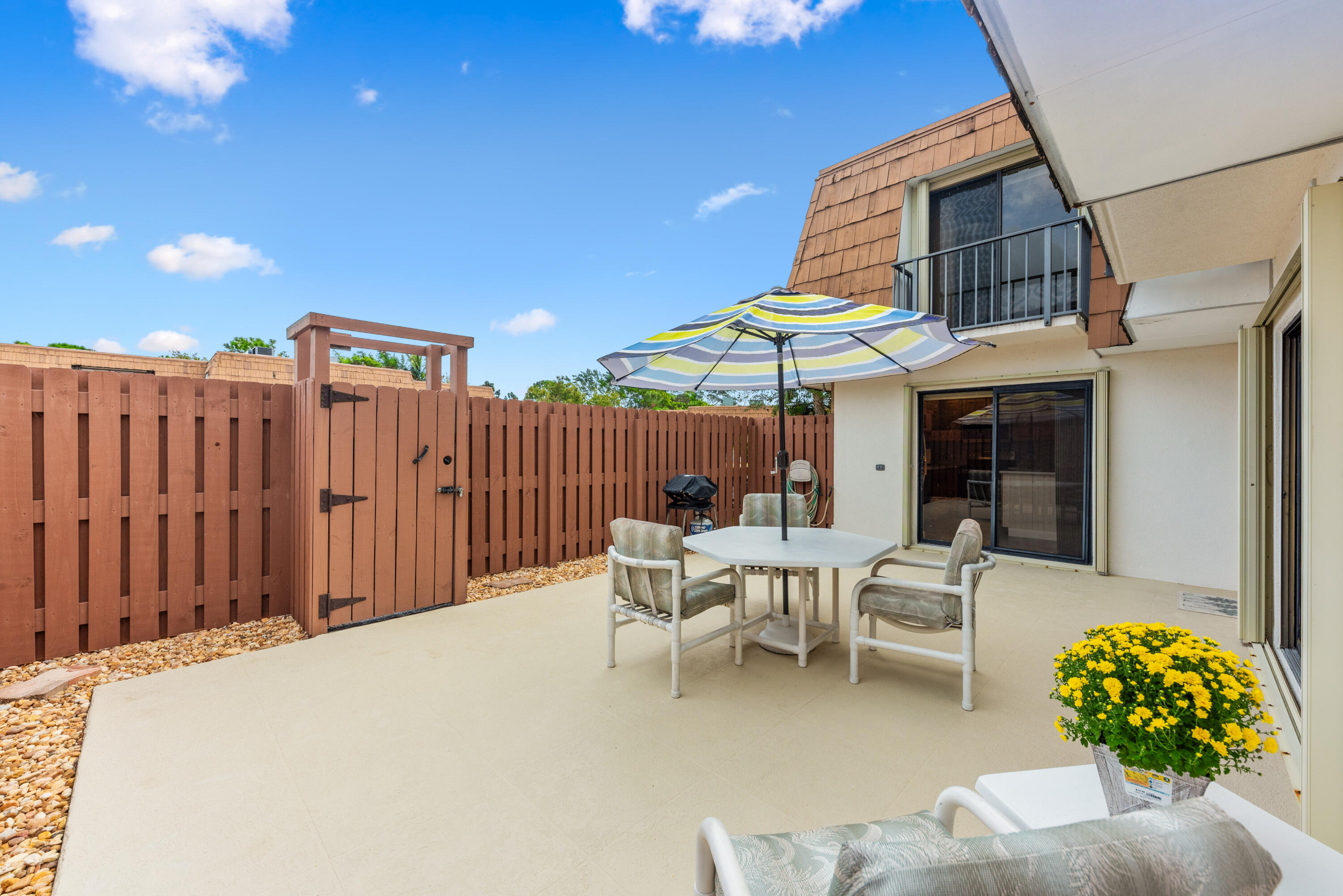 a patio with table and chairs and potted plants