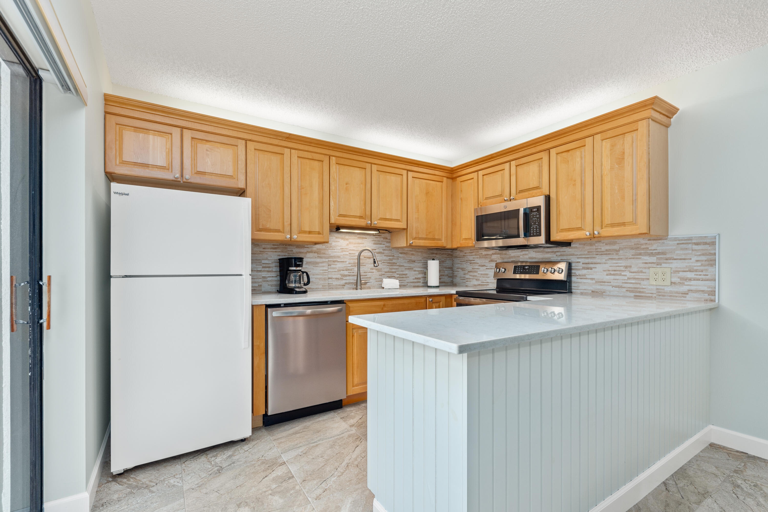 5874 Southeast Riverboat Drive, Unit 330 Stuart, FL 34997 - Photo 13 of 40 a kitchen with stainless steel appliances granite countertop a refrigerator stove a sink dishwasher and microwave