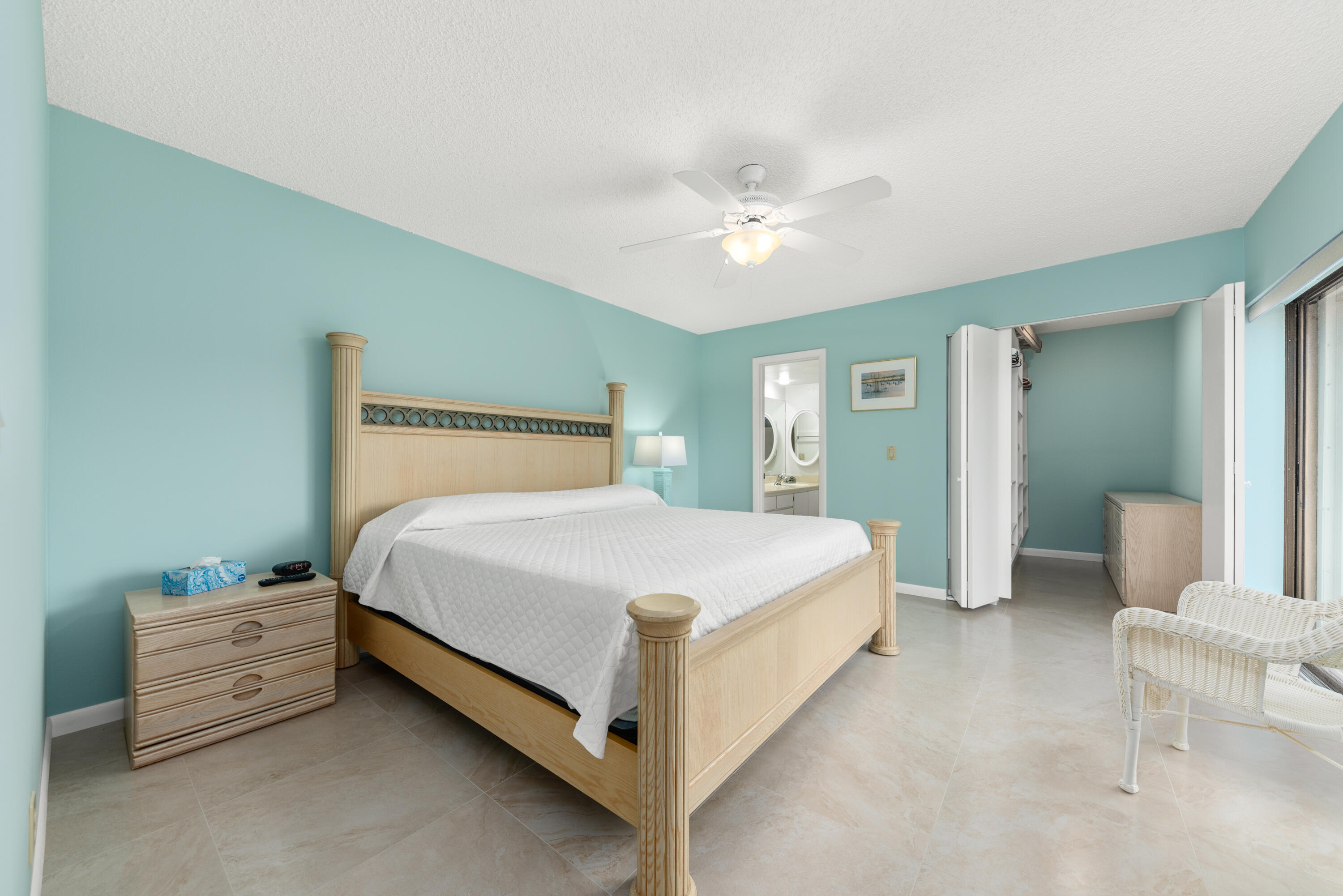 5874 Southeast Riverboat Drive, Unit 330 Stuart, FL 34997 - Photo 18 of 40 a bedroom with a bed and a chandelier