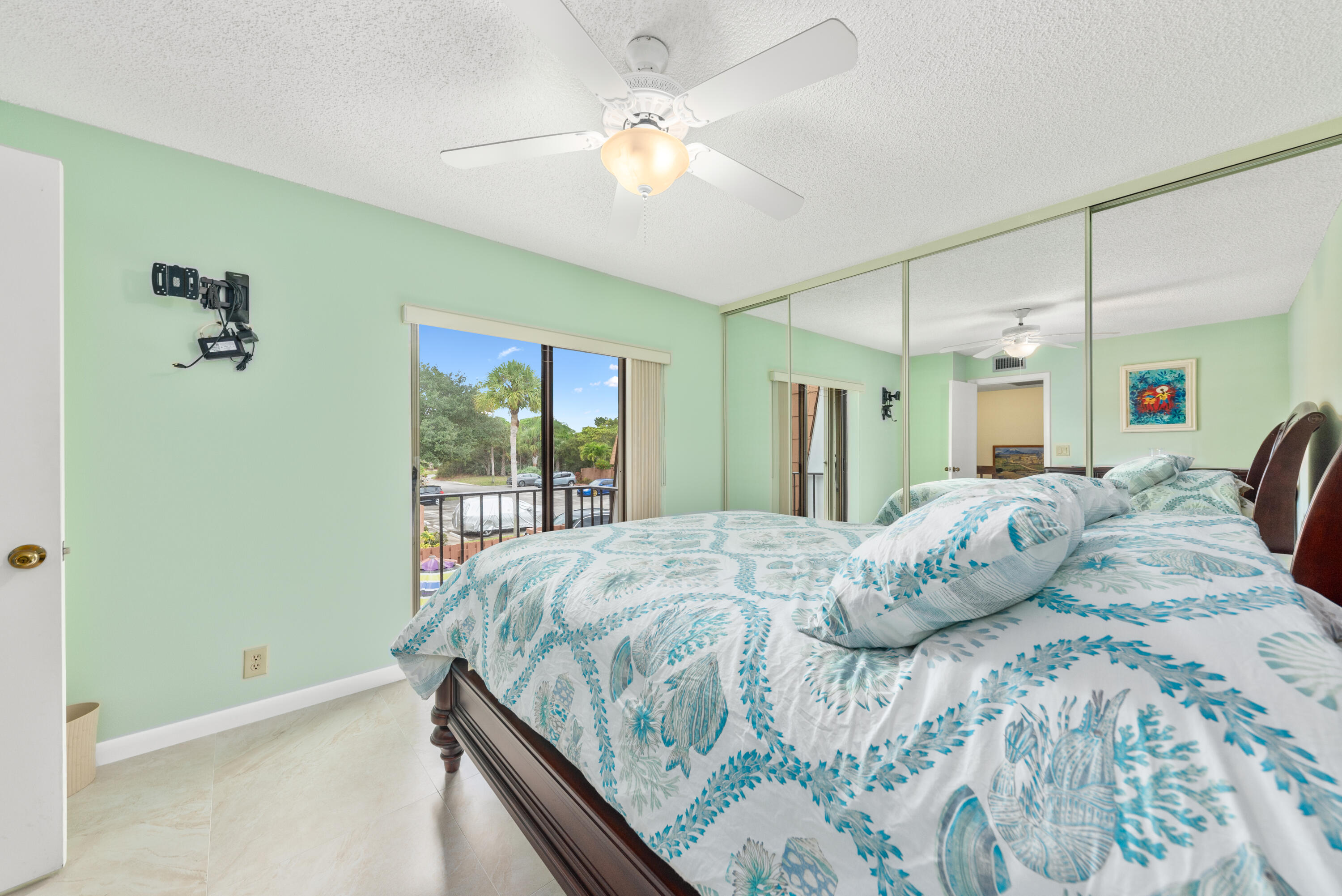 5874 Southeast Riverboat Drive, Unit 330 Stuart, FL 34997 - Photo 24 of 40 a bedroom with a large bed and a chandelier