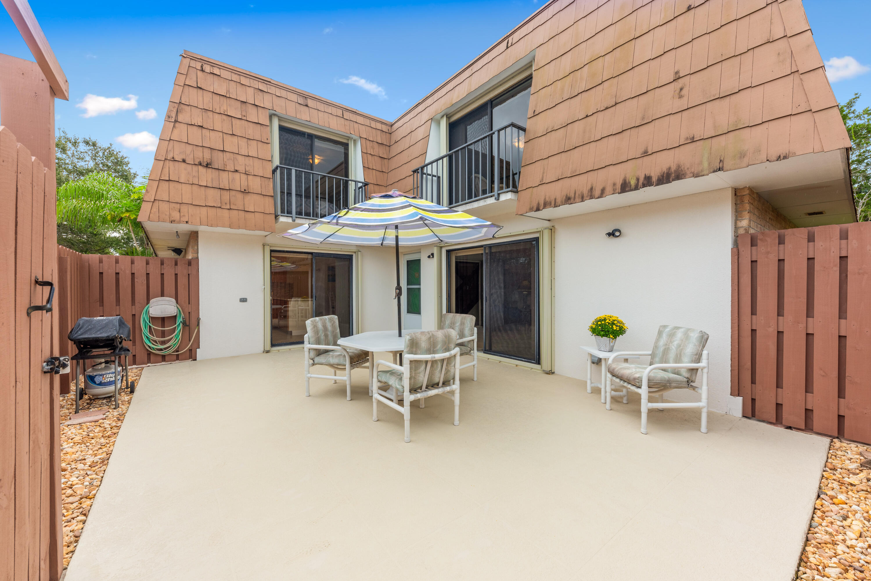 5874 Southeast Riverboat Drive, Unit 330 Stuart, FL 34997 - Photo 37 of 40 a view of a patio with a table and chairs under an umbrella