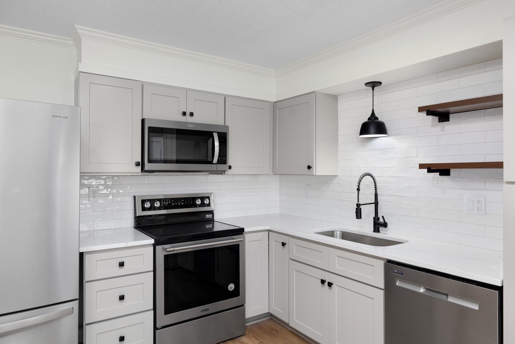 426 Homeville Road Collierville, TN 38017 - Photo 3 of 23 a kitchen with white cabinets and black appliances