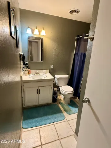 a bathroom with a sink a toilet a mirror and shower