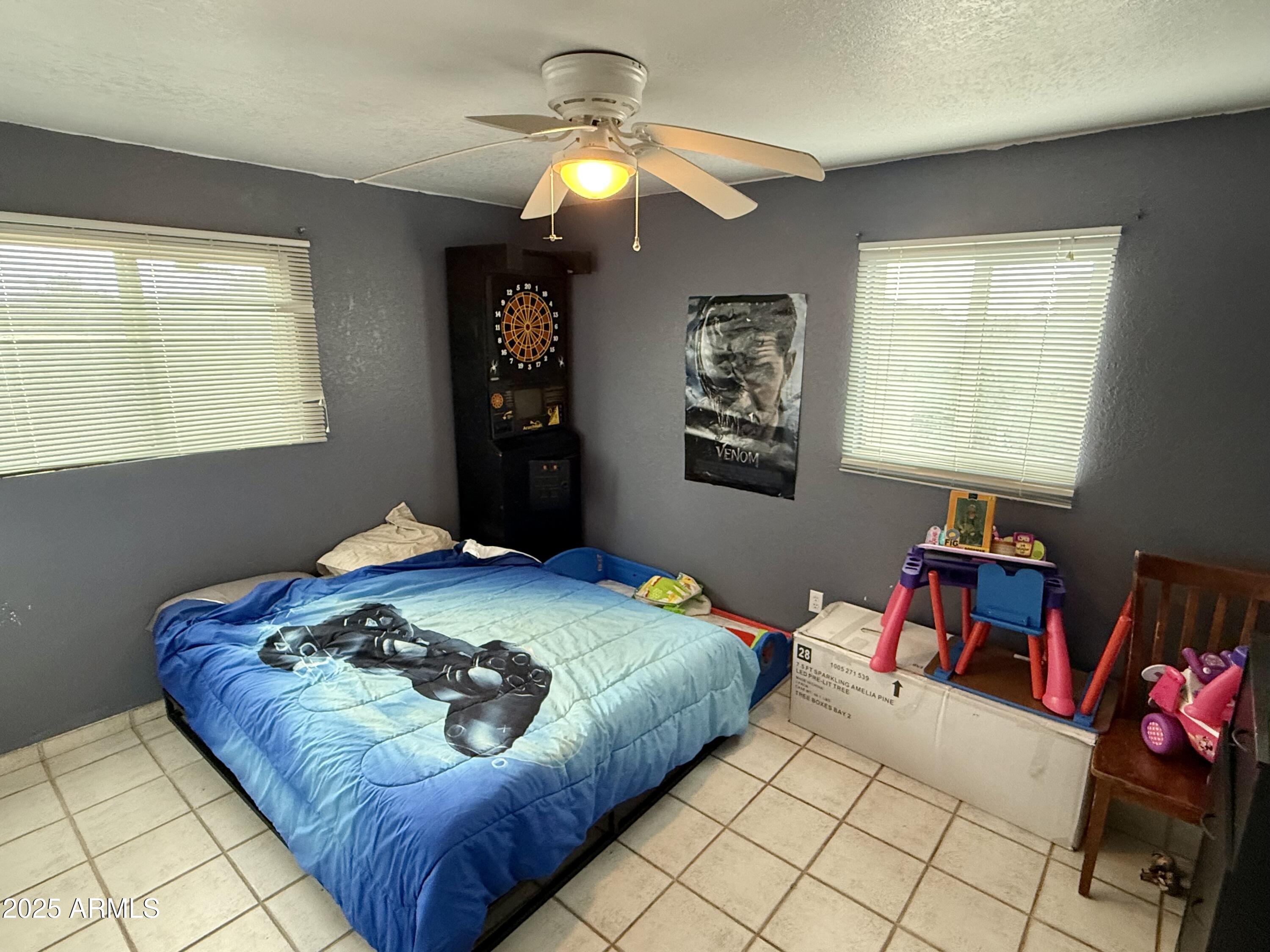 2535 East Roadrunner Ridge Tombstone, AZ 85638 - Photo 16 of 20 a bedroom with a bed and a chandelier