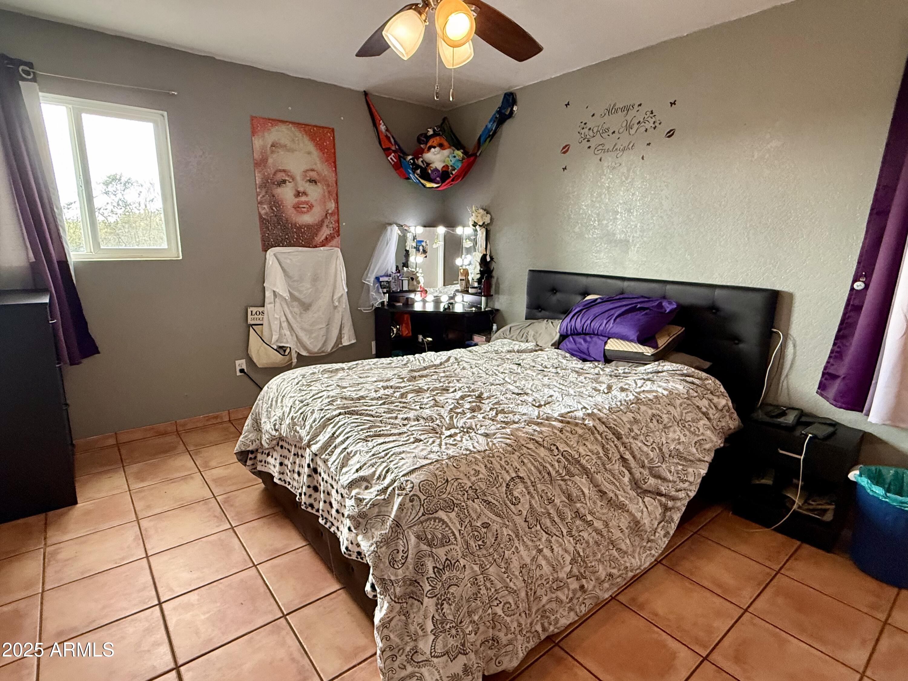 2535 East Roadrunner Ridge Tombstone, AZ 85638 - Photo 17 of 20 a bedroom with a bed and a chandelier