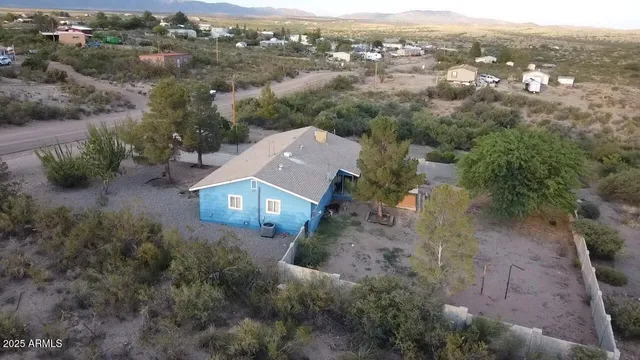 an aerial view of a house with a mountain in the background