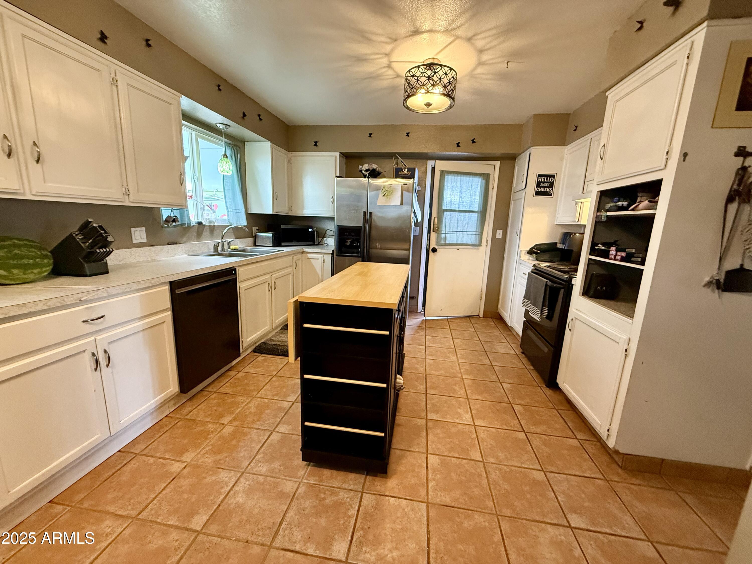 2535 East Roadrunner Ridge Tombstone, AZ 85638 - Photo 5 of 20 a kitchen with stainless steel appliances granite countertop a stove top oven a sink a counter space and cabinets