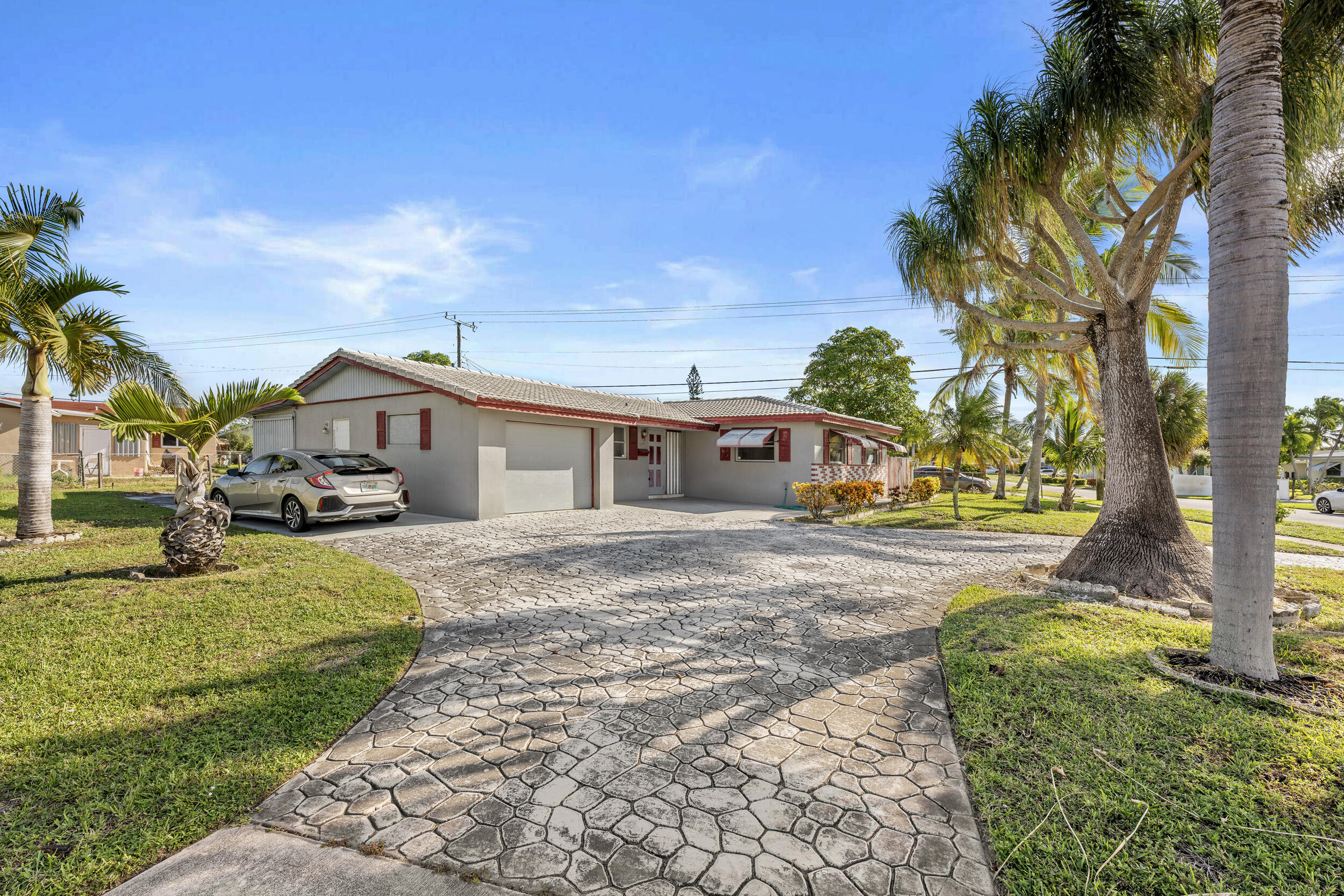 490 West 31st Street Riviera Beach, FL 33404 - Photo 4 of 29 a front view of a house with a yard outdoor seating and covered with trees