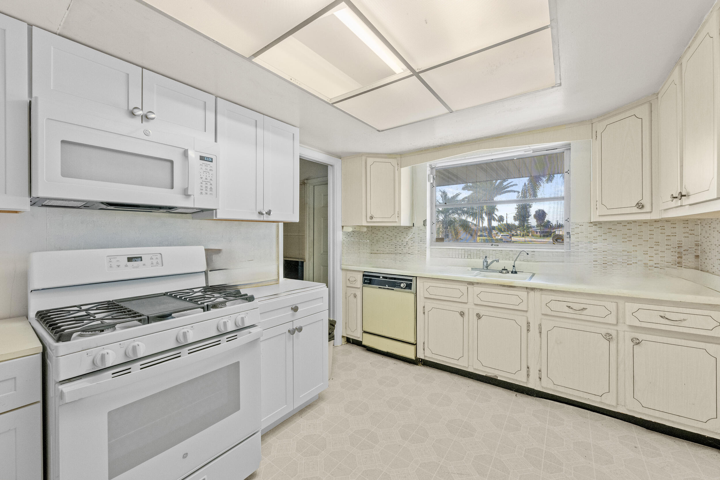 490 West 31st Street Riviera Beach, FL 33404 - Photo 5 of 29 a kitchen with granite countertop cabinets stainless steel appliances and a sink