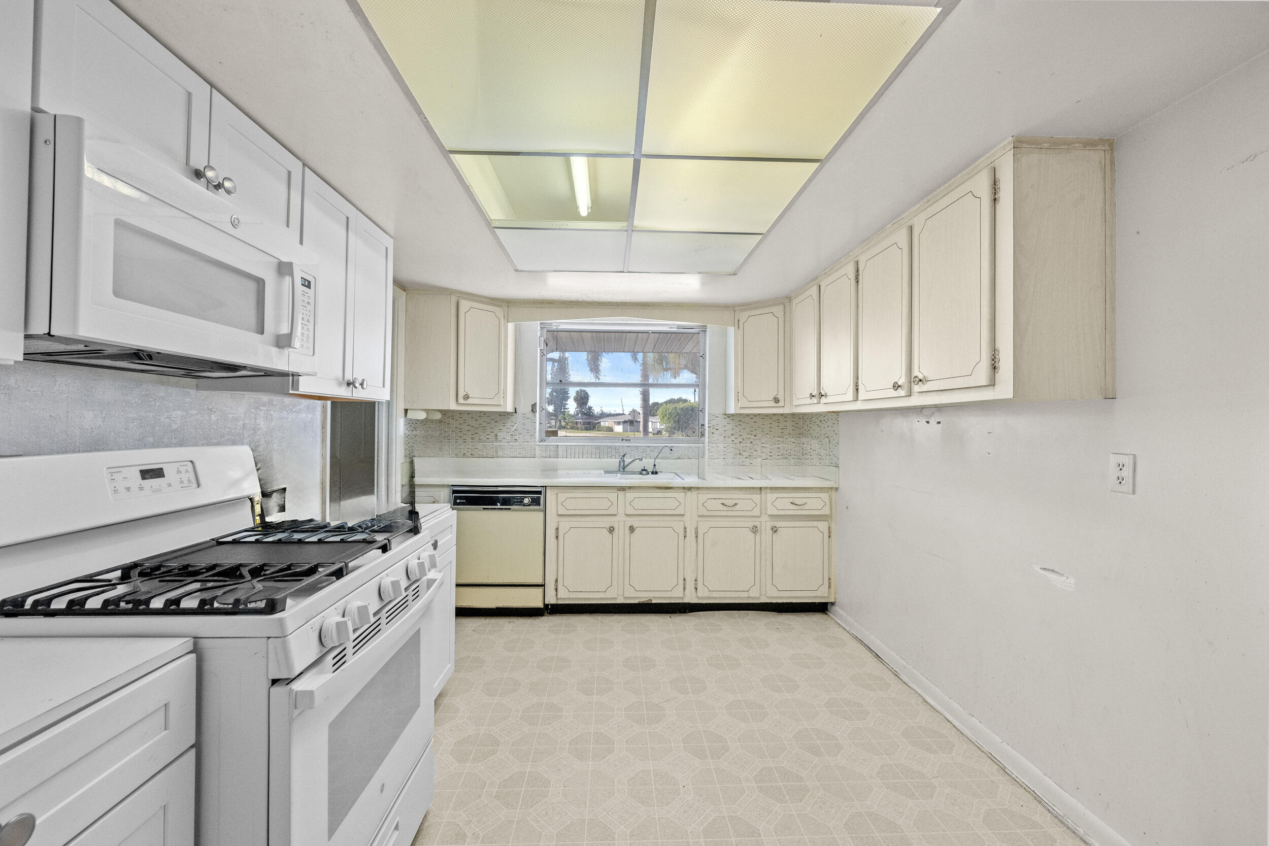 490 West 31st Street Riviera Beach, FL 33404 - Photo 6 of 29 a kitchen with granite countertop a stove sink and cabinets