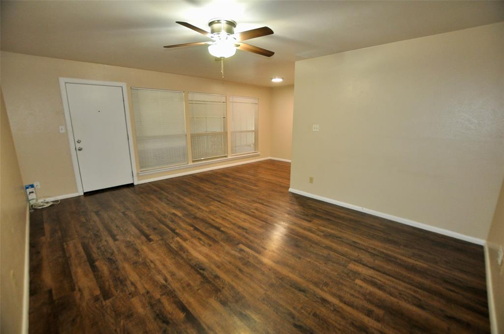 202 East Oak Street, Unit 12 Weatherford, TX 76086 - Photo 6 of 8 an empty room with wooden floor and windows