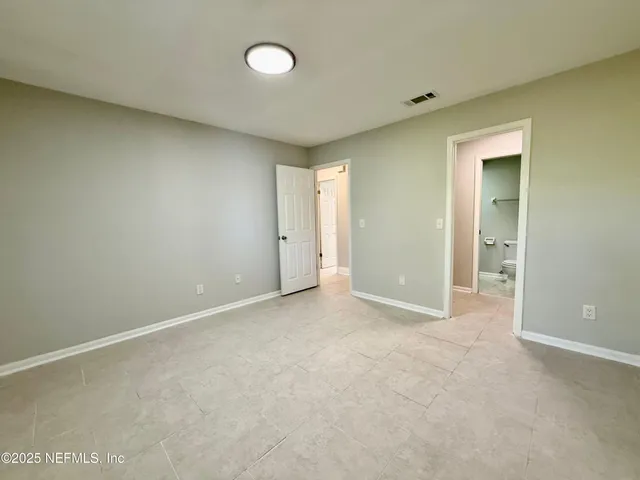 an empty room with windows and bathroom view