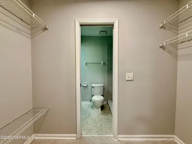 a bathroom with a granite countertop toilet and a shower