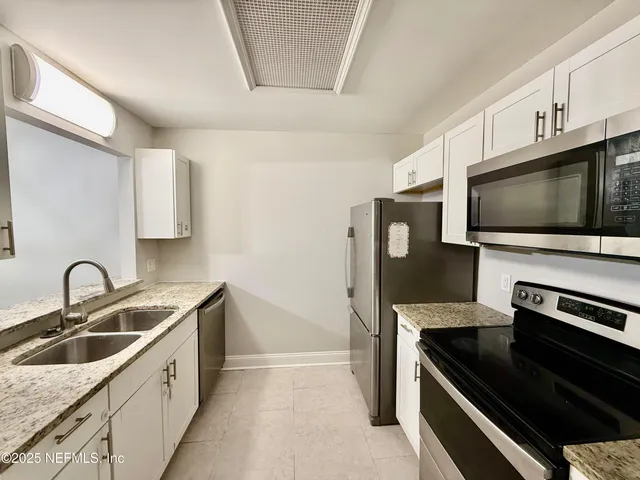 a kitchen with a sink and a stove top oven