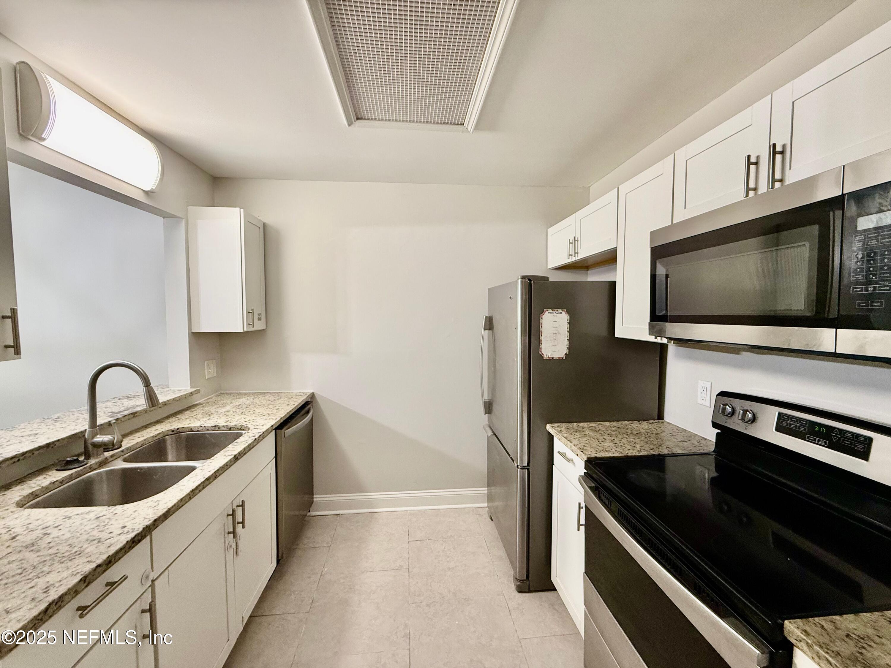 3801 Crown Point Road, Unit 1074 Jacksonville, FL 32257 - Photo 8 of 22 a kitchen with a sink and a stove top oven