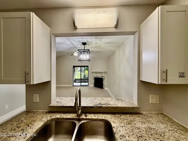 a kitchen with a granite countertop sink and stove