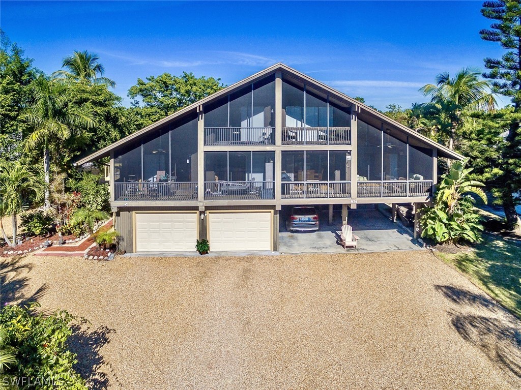 974 Sand Castle Road Sanibel, FL 33957 - Photo 2 of 31 a front view of a house with a yard