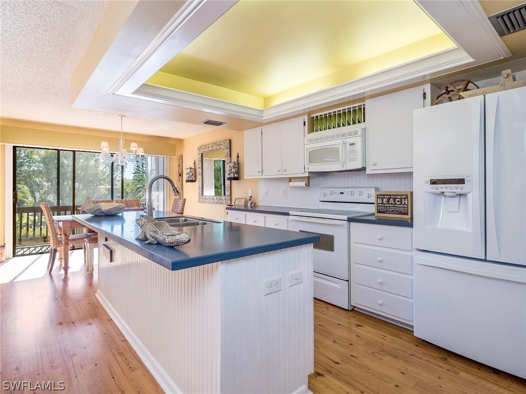 974 Sand Castle Road Sanibel, FL 33957 - Photo 8 of 31 a kitchen with stainless steel appliances granite countertop a sink stove and refrigerator