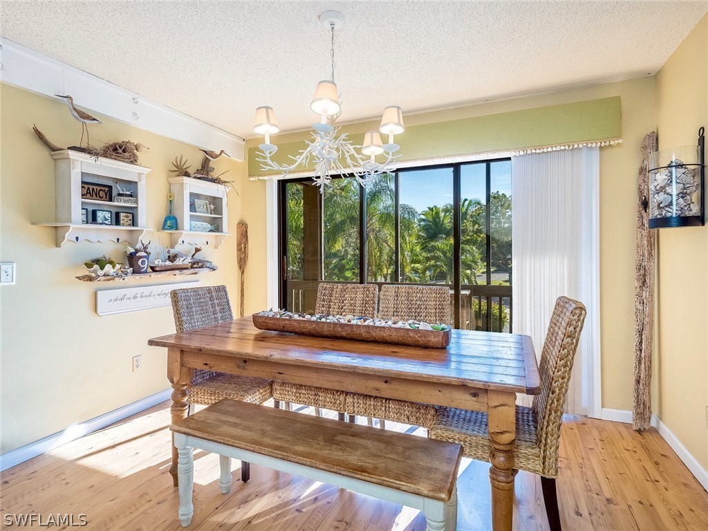974 Sand Castle Road Sanibel, FL 33957 - Photo 10 of 31 a view of a dining room with furniture large windows and wooden floor