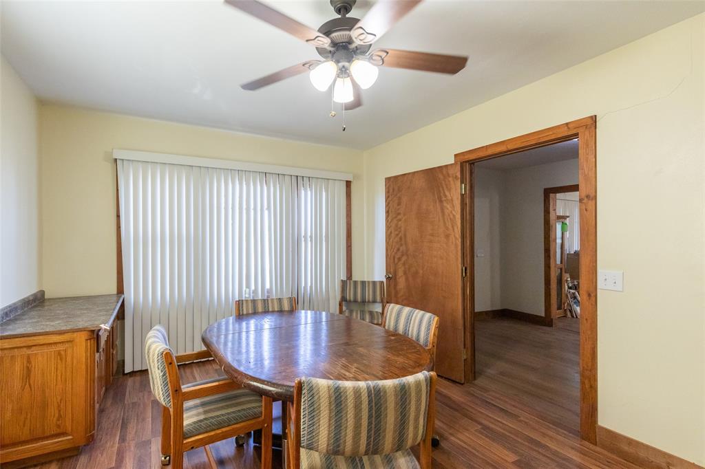 640 Ground Street Moran, TX 76464 - Photo 11 of 35 Dining area featuring wood-finish flooring, a ceiling fan with light fixture, and a built-in cabinetry unit with countertop