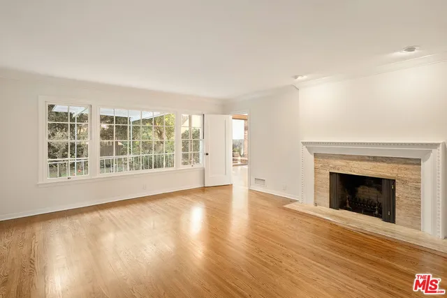 wooden floor fireplace and windows in an empty room