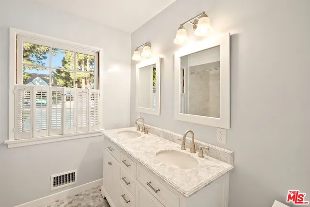 a bathroom with a granite countertop sink and a mirror