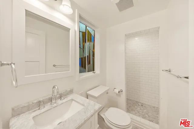 a bathroom with a sink toilet vanity and shower
