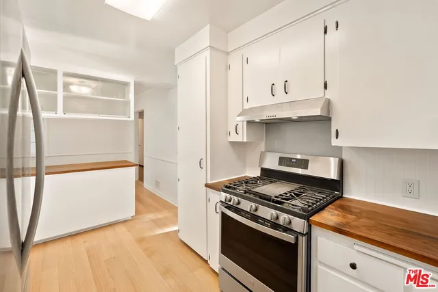 a kitchen with granite countertop a stove and a refrigerator