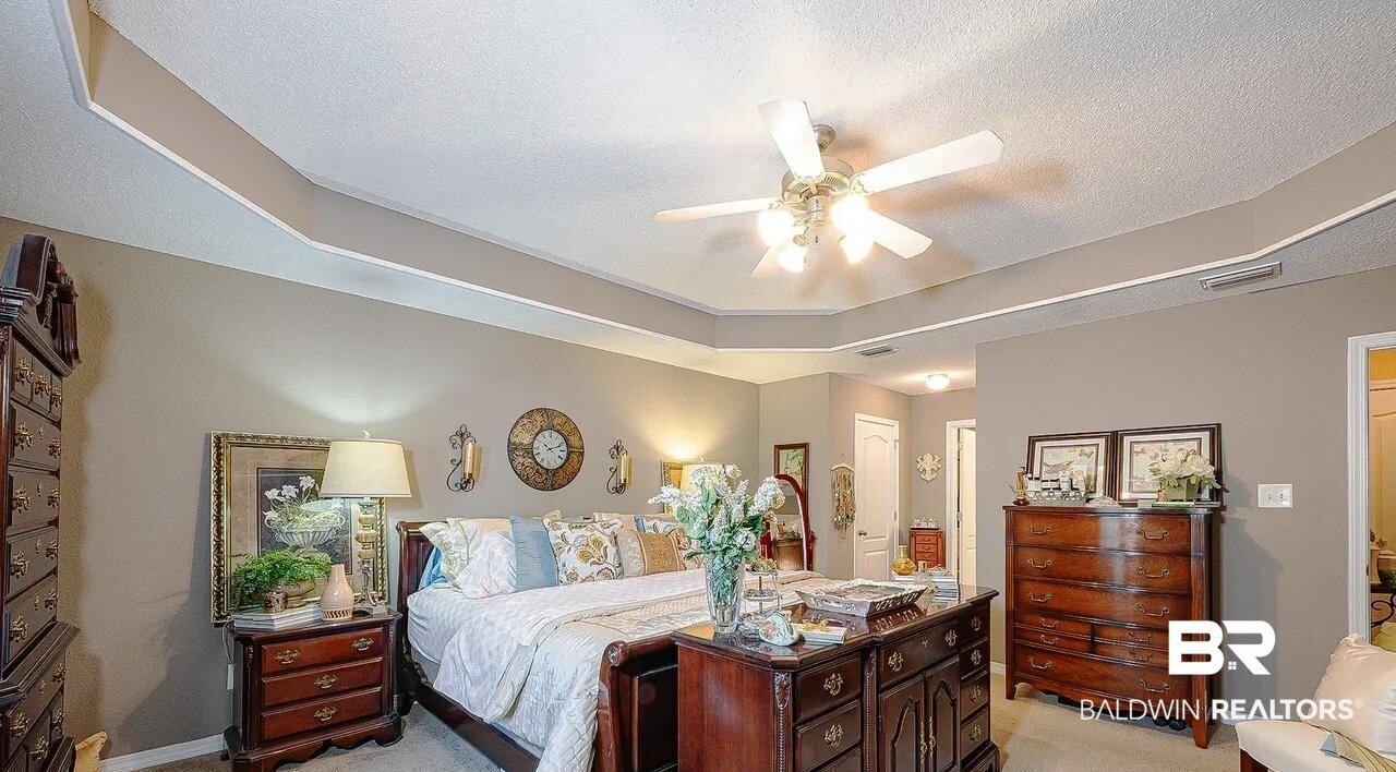 12230 Bromley Road Stapleton, AL 36578 - Photo 20 of 34 Bedroom with light colored carpet, a tray ceiling, ceiling fan, a textured ceiling, and connected bathroom