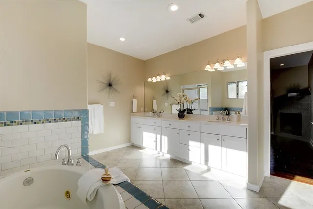 a large bathroom with a large tub and sink
