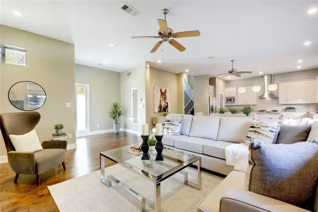 a living room with furniture kitchen view and a chandelier