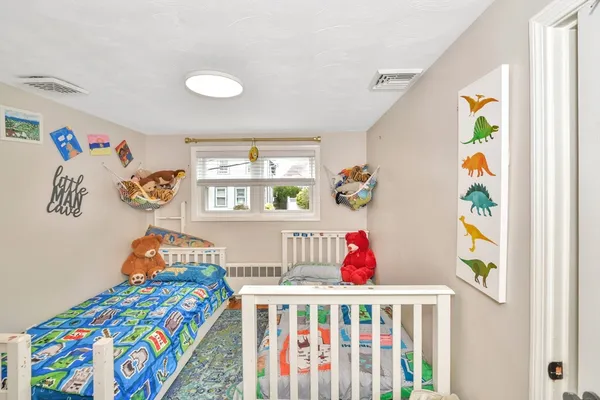 a bedroom with baby bed toys and paintings on the wall