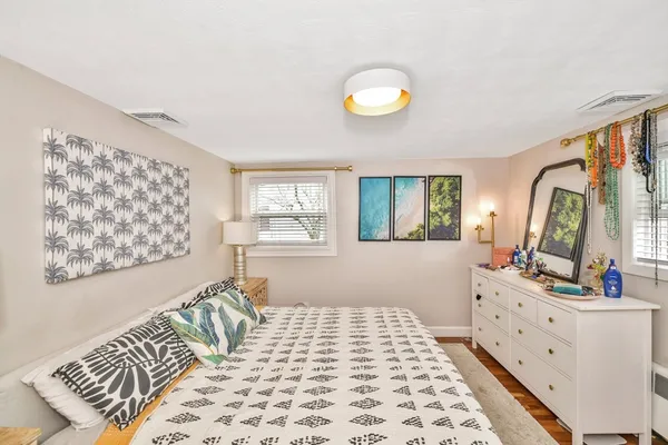 a bedroom with a bed and wooden floor