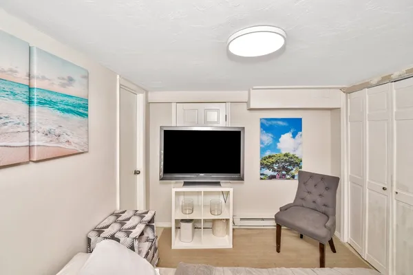 a living room with furniture a flat screen tv and a floor to ceiling window