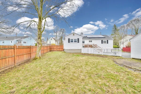 a view of a house with a large tree with wooden fence