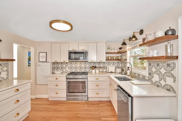 a kitchen with stainless steel appliances kitchen island granite countertop a refrigerator and a stove
