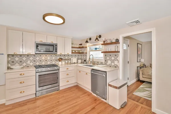 a kitchen with granite countertop white cabinets and white appliances
