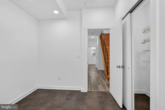 an empty room with wooden floor and a bathroom