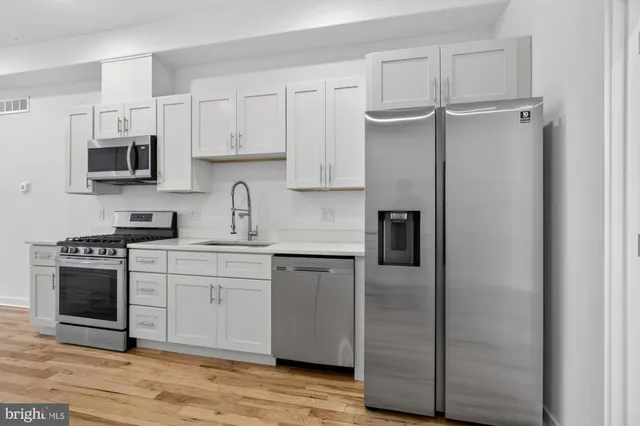 a kitchen with white cabinets and stainless steel appliances